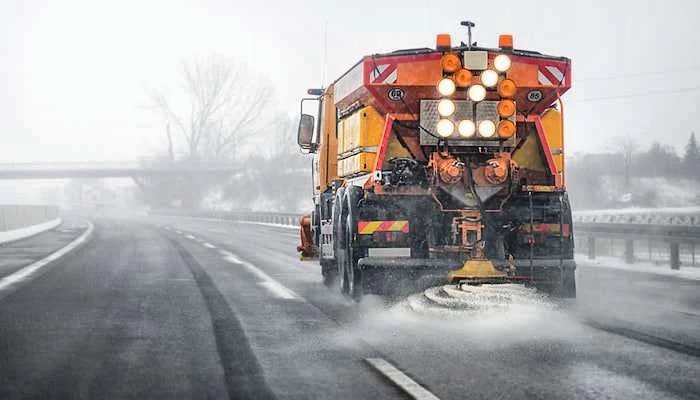 A salt truck de-icing a highway